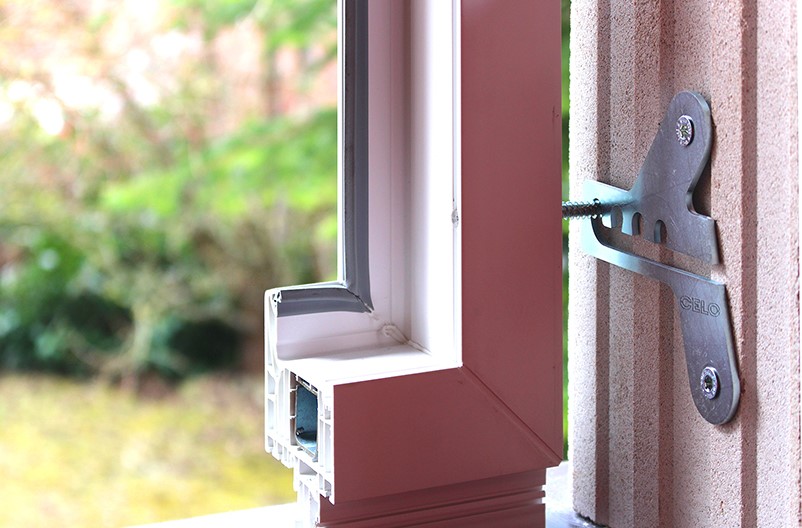 Fenstersicherungslasche ProtectFIX installiert am Fensterrahmen mit Aussicht zum Garten